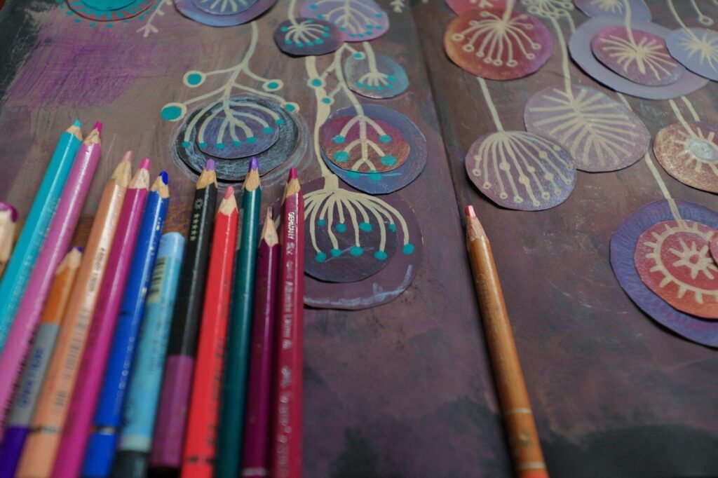 Colored pencils and artwork with floral designs.